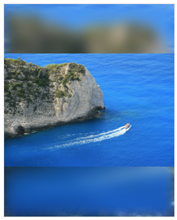 View of a cliff above the blue sea with a boat sailing along the coast and blured background